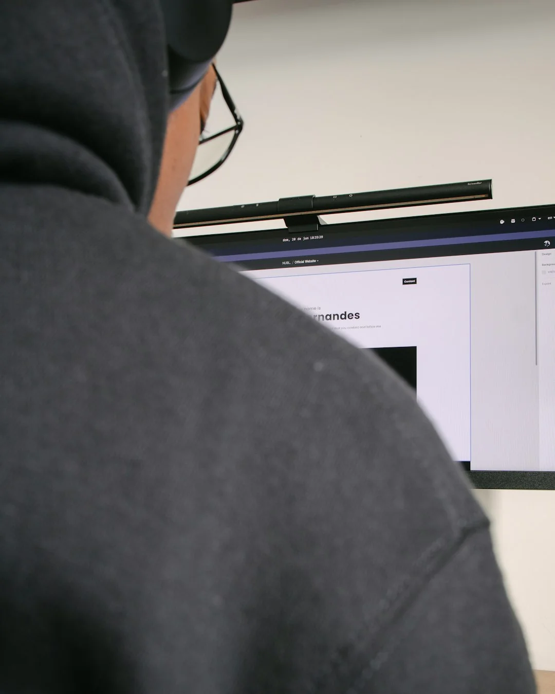 Hands holding a credit card while online shopping on a laptop at a wooden table.